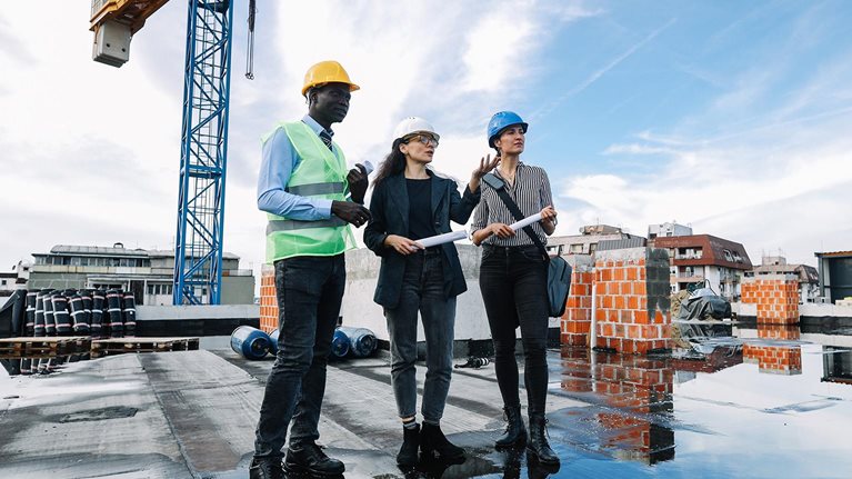 Architects and investors meeting at the construction site, on top of the residential building under construction. - stock photo