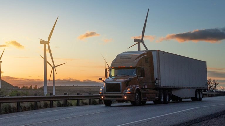 Semi truck speeding in front of Wind turbines in Utah, USA - stock photo