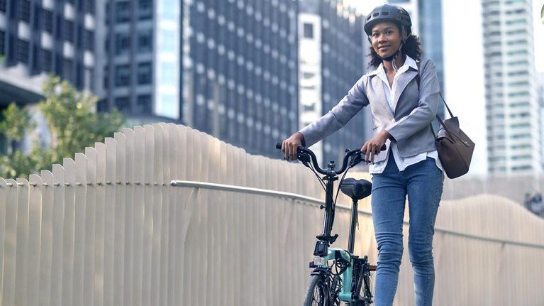Image of a woman cycling to work in a city.