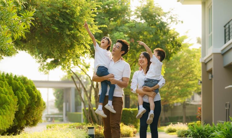 Asian Young happy family of four walking together outdoor. Parents with son and daughter look happy and smile. Happiness and harmony in family life.