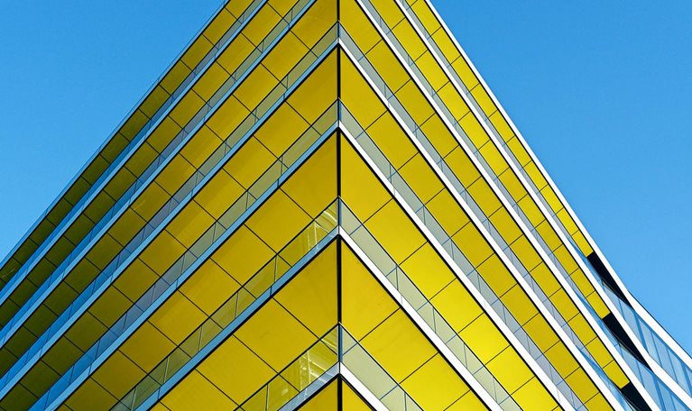 Low angle view of contemporary office building in Central London. Yellow ceilings, blue sky