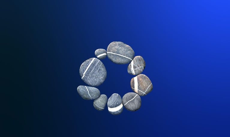 A circle made up of nine smooth, gray river stones sits on a dark blue gradient. Each stone contains a white vein, forming a secondary circle when they are arranged in this way.