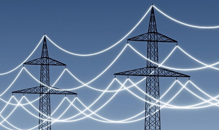 Electricity pylons with glowing power lines to emphasize technology