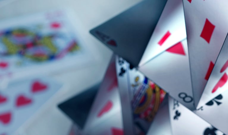 A house of cards built with a variety of playing cards.