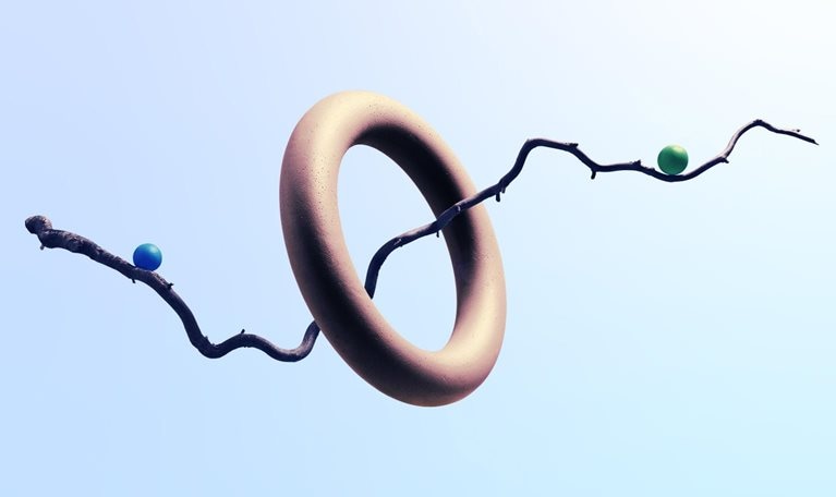 A twisty branch floating though a ring with 2 marbles balancing on each side. The branch subtly resembles a line graph with an upward trend.