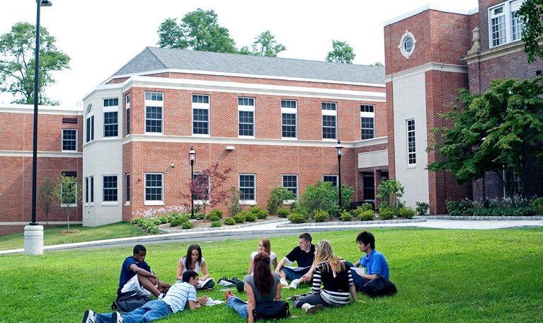 Group of friends (16-19) studying outdoors - stock photo