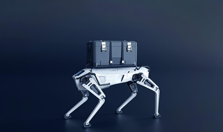 A robotic dog with a sleek white design and black detailing has a large gray container strapped to its back.