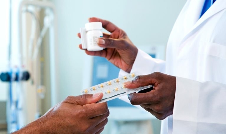 Doctor handing medication to patient