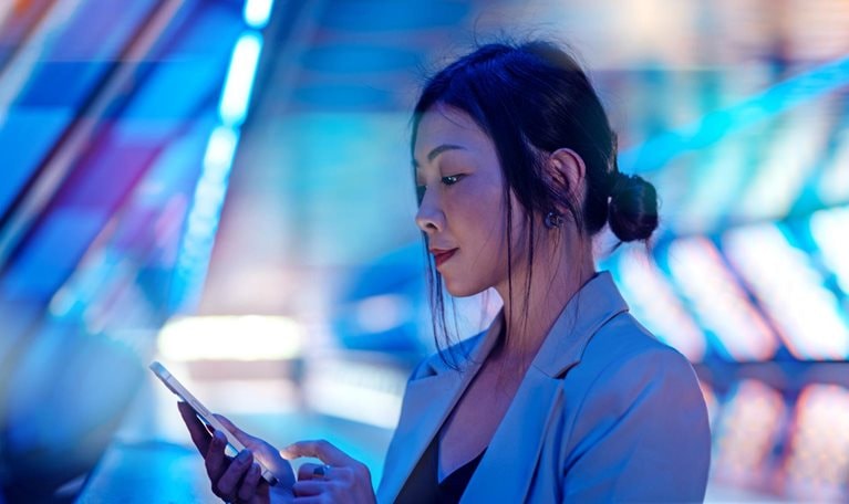 Young Asian business woman using smart phone in a Virtual Reality (VR) environment