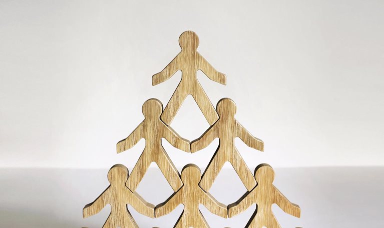 Wooden stick figures stacked in a pyramid.