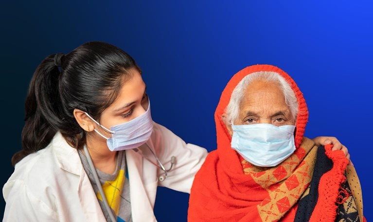 Indian female doctor comforting and giving mental support to senior woman patient at home.