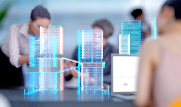 Engineers and architects working in a modern office with a building project visualized with augmented reality software.