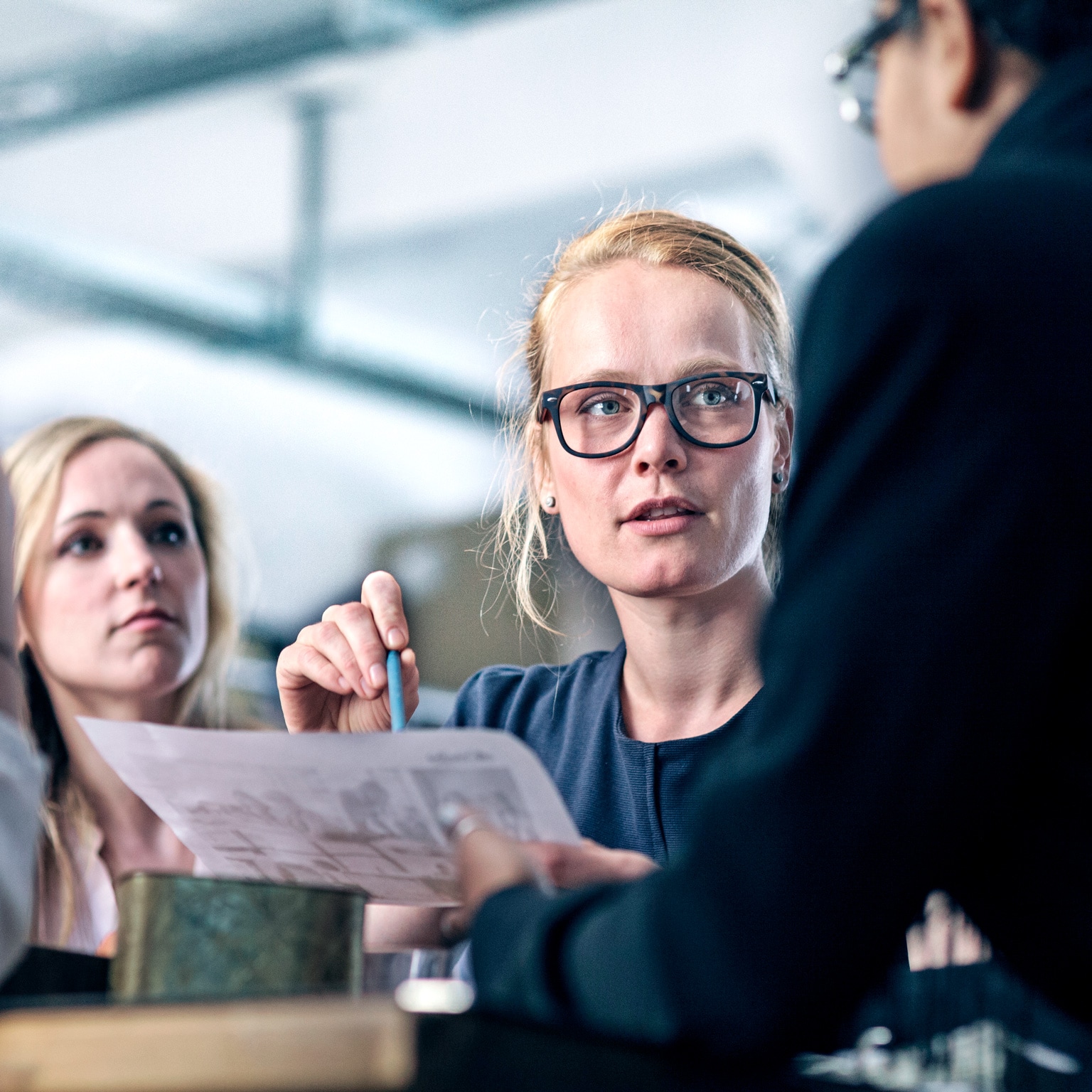 Image of a woman leading her team in business meeting