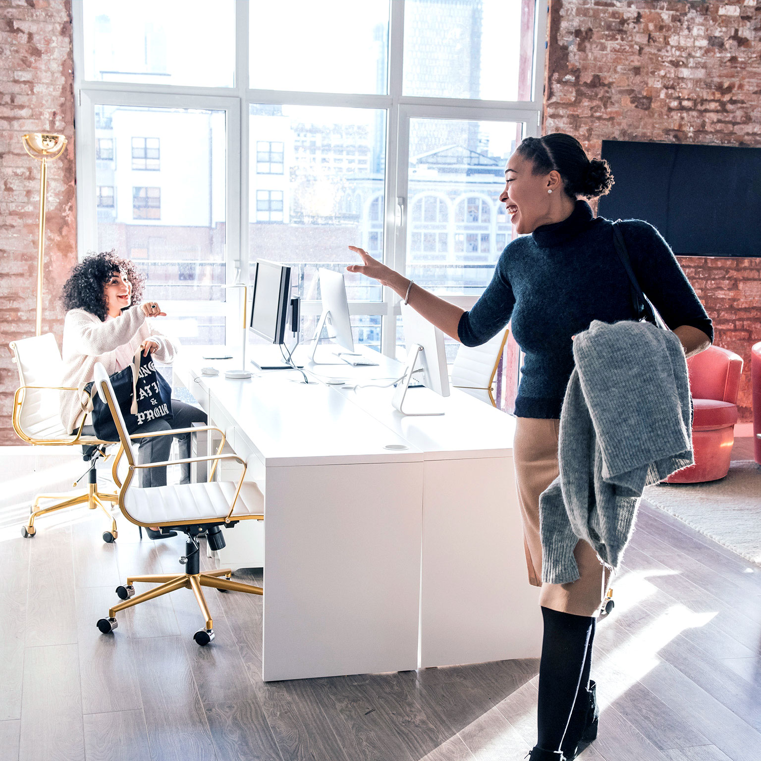 Image of a woman waving goodbye to colleague in office