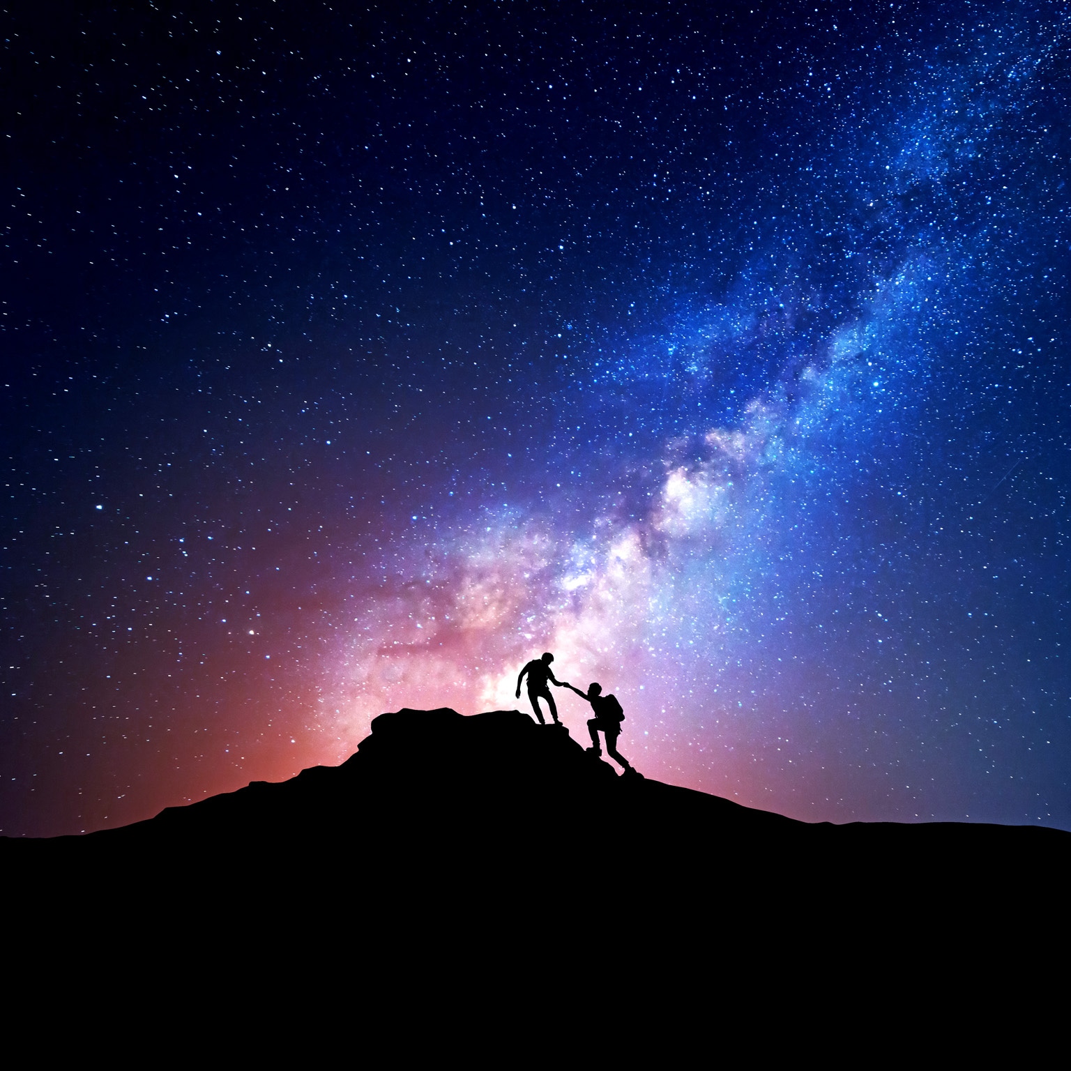 Image of a silhouette of people climbing mountain at night