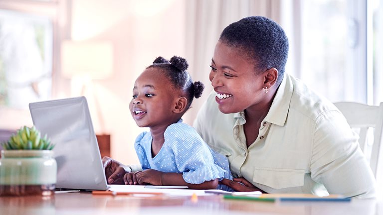 Image of a Black mother and her child looking at a laptop