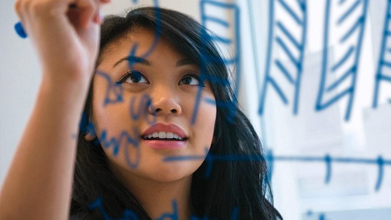 Image of a young Asian woman writing with a Sharpie