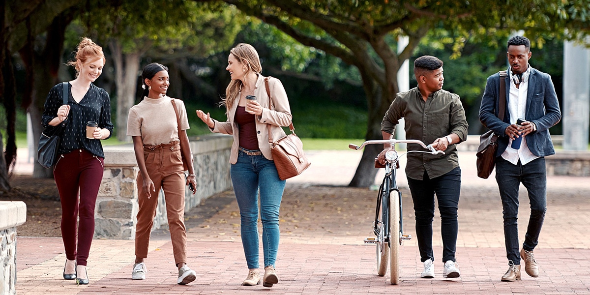 Image of five people walking down the street and talking