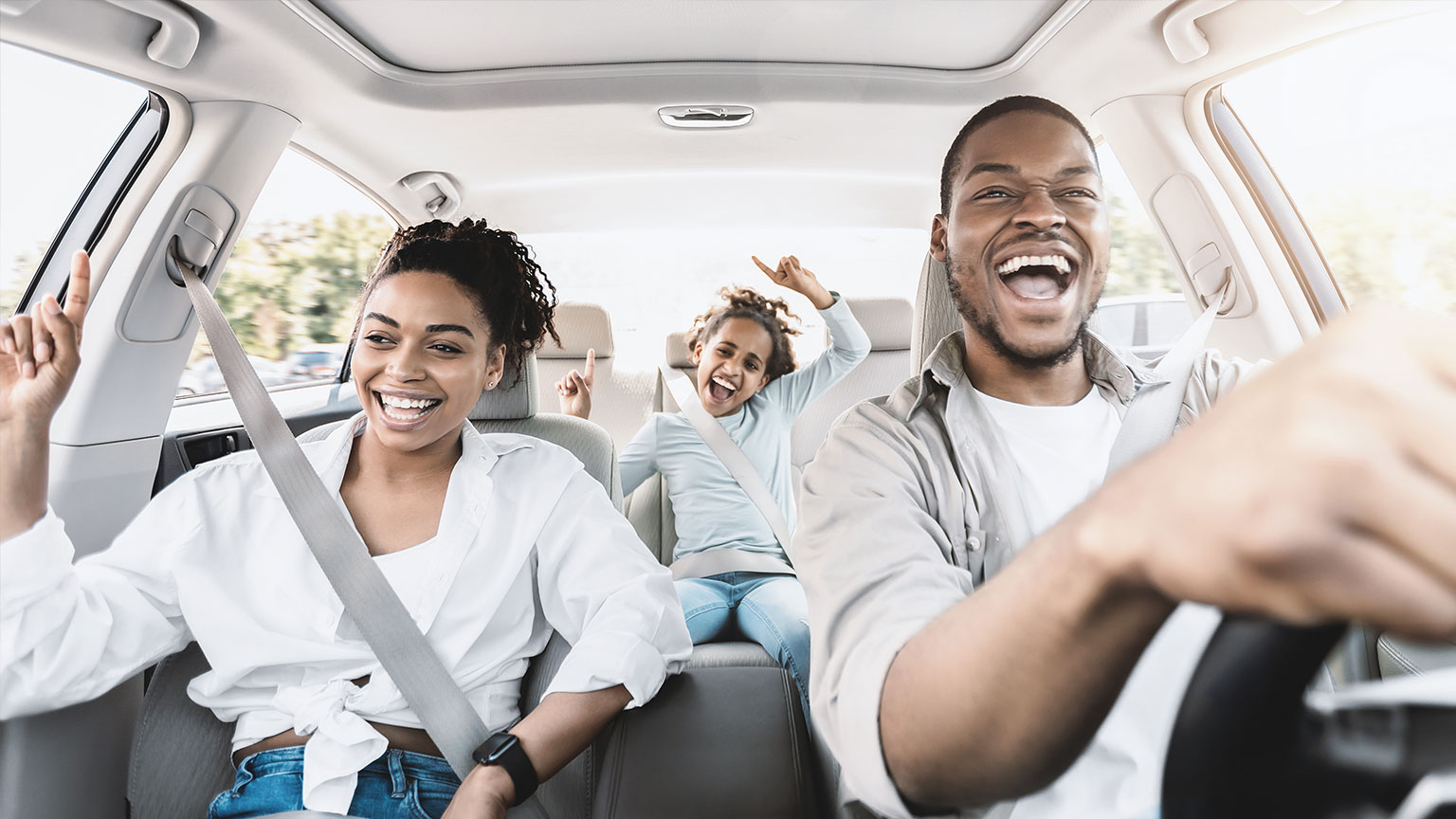 Image of a Black family of three in a car