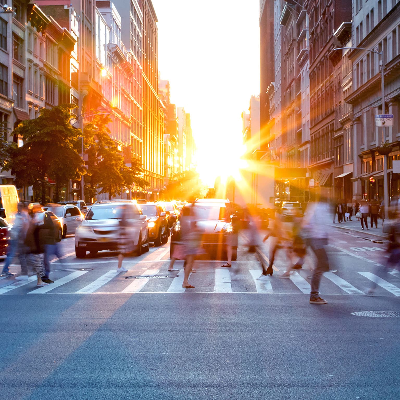 Sun setting between city buildings