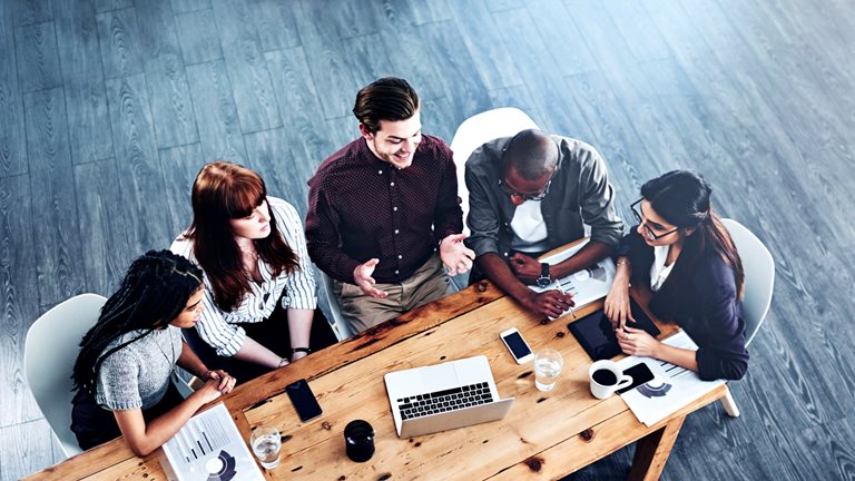 Image of several people having discussions in the course of a meeting