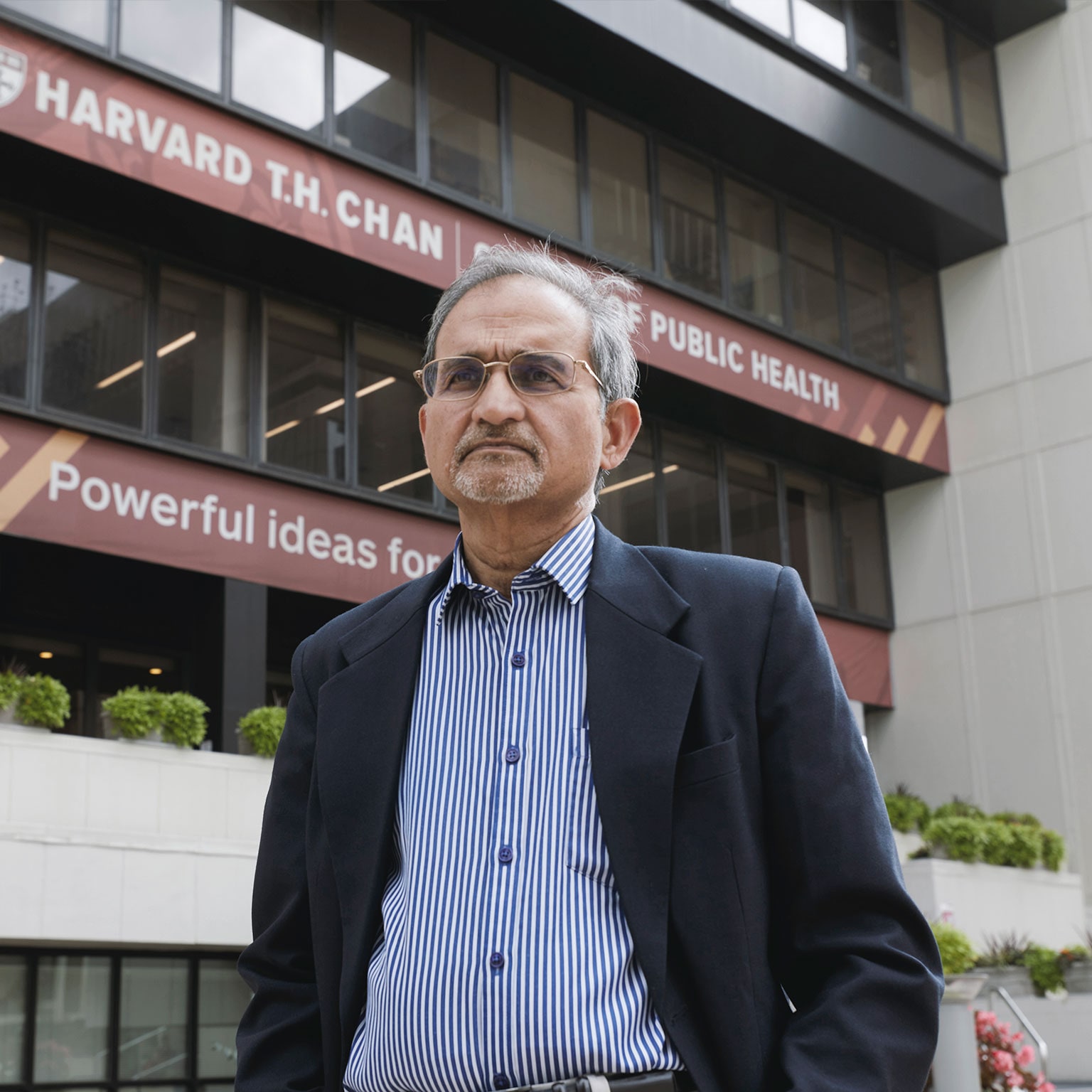 Dr. Shekhar Saxena stands in front of Harvard’s T.H. Chan School of Public Health. Photo by Kent Dayton