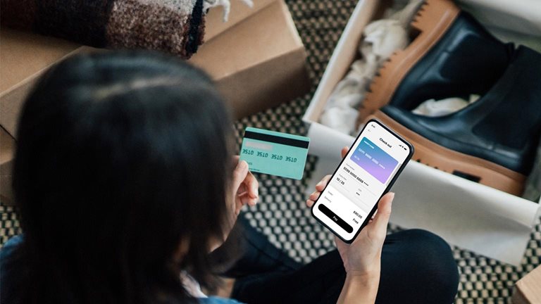 Overhead View Of Young Woman Doing Online Shopping With Smart Phone