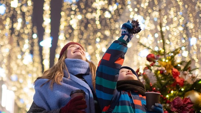 Little boy with his mother buying tera and sweets at a Christmas market.