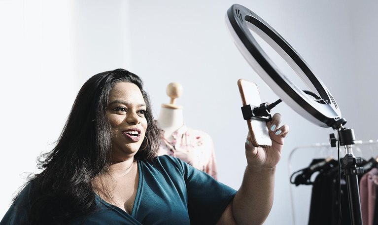 Woman taking selfie with light prop