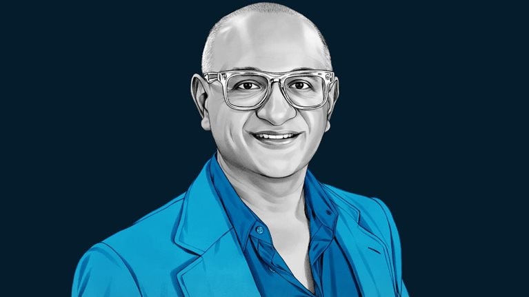 A hand-drawn illustration of Jeetu Patel, smiling and wearing glasses, and a blazer over a collared shirt. The drawing features precise lines and subtle shading, using black and white tones for her face and blues for her attire.