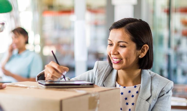 Courier collecting or delivering parcels from small business - stock photo