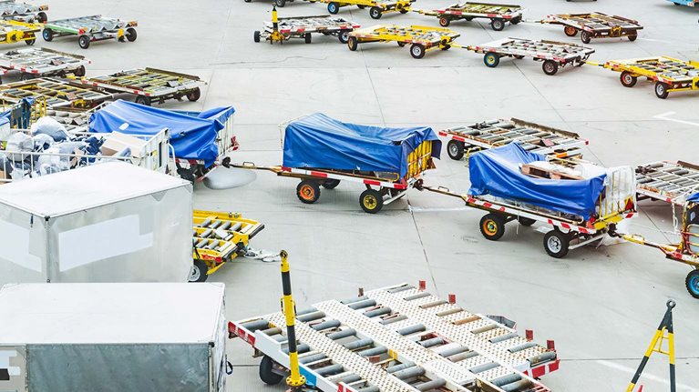 Cargo carts on the airport field, loaded and unloaded before the flight