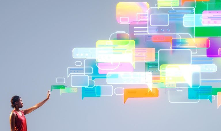 A person reaches into a cascade of colorful message bubbles, symbolizing agentic AI orchestrating empathetic, human-centered customer conversations at scale.