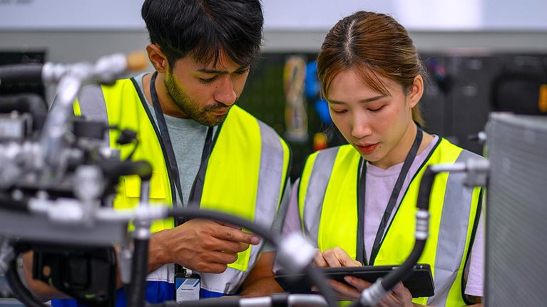 Mechanics are working at EV car workshop.