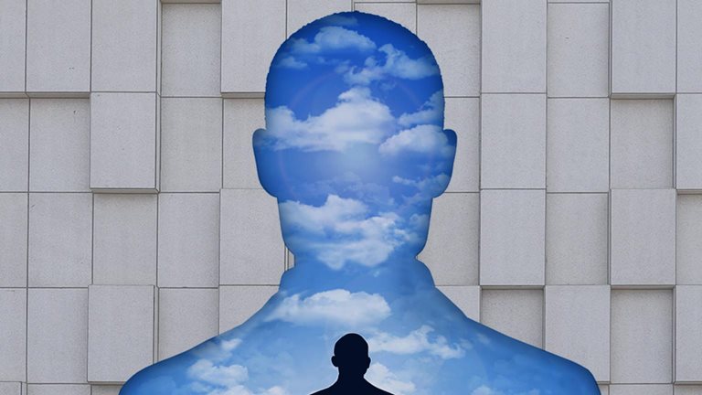 A silhouette of an executive's torso creates a cutout in a corporate wall, filled with a landscape that predominantly features the sky. In that landscape, a smaller silhouetted figure sits on the ground, lost in deep contemplation.