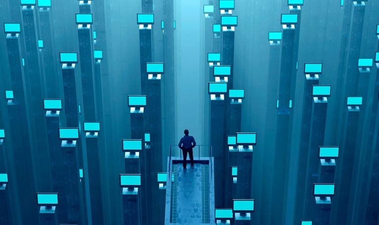 Man watching abundance of glowing computer monitors