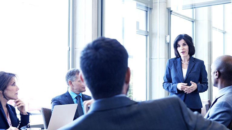 Businesswoman talking with colleagues during meeting in office