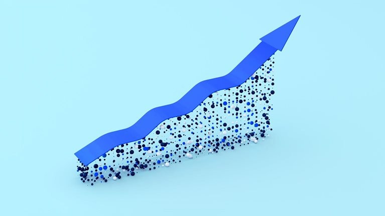 A blue arrow trending upwards symbolizes growth. The arrow appears to be constructed on a foundation of small blue, black, and white spheres, creating a dynamic and textured effect.