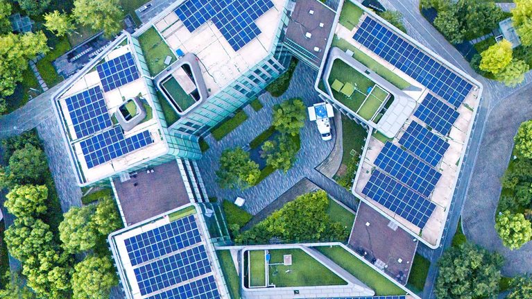 Solar panels on city rooftops at dusk