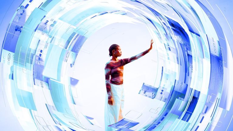 A woman stands at the center of a glowing, circular digital interface composed of layered blue and white translucent panels. She reaches out with her hand to touch the futuristic data displays that surround her in a dynamic, swirling formation.