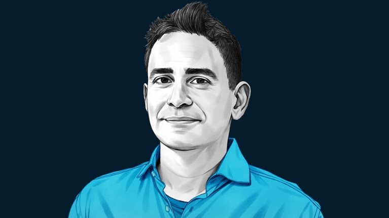 A hand-drawn illustration of Elad Gil, with a light smile, short dark hair and wearing a collared shirt. The drawing features precise lines and subtle shading, using black and white tones for her face and blues for her attire.