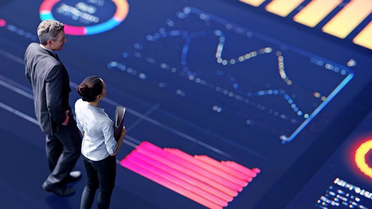 3d conceptual rendering of two business people standing on a large digital screen, analyzing data visualizations.
