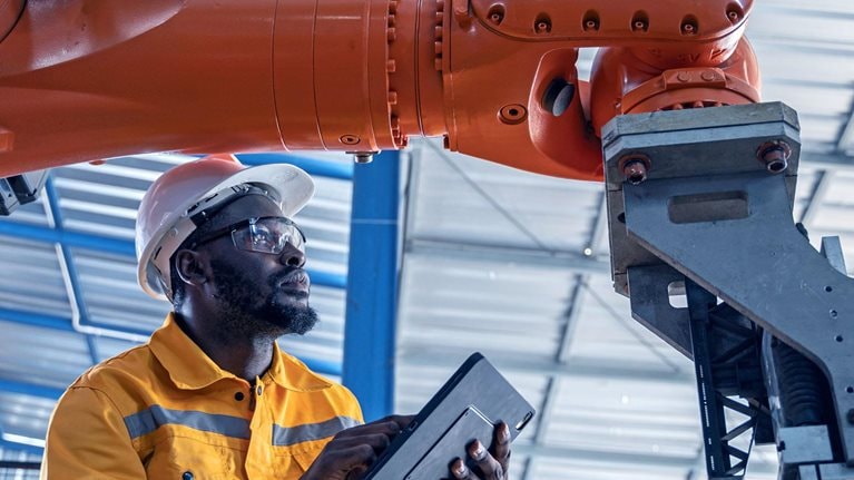 Engineer working with machinery at industrial manufacturing plant.