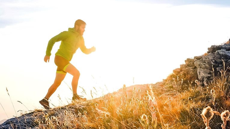 Italy, man running on mountain trail