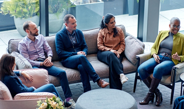Five colleagues sitting in a group talking.