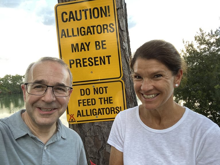 Kevin and wife in front of a alligator caution sign