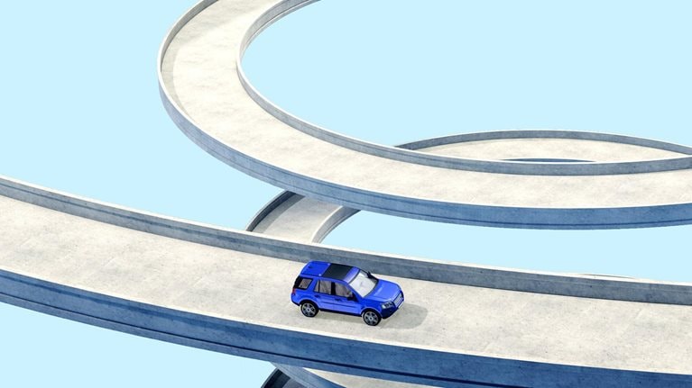 A conceptual depiction of a blue vehicle traversing a lengthy, curving pathway in a spiral form. The backdrop is a uniform, pale blue hue.