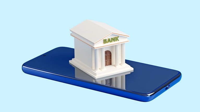 A stylized miniature bank building with the word "BANK" on its facade sits on top of a blue smartphone.