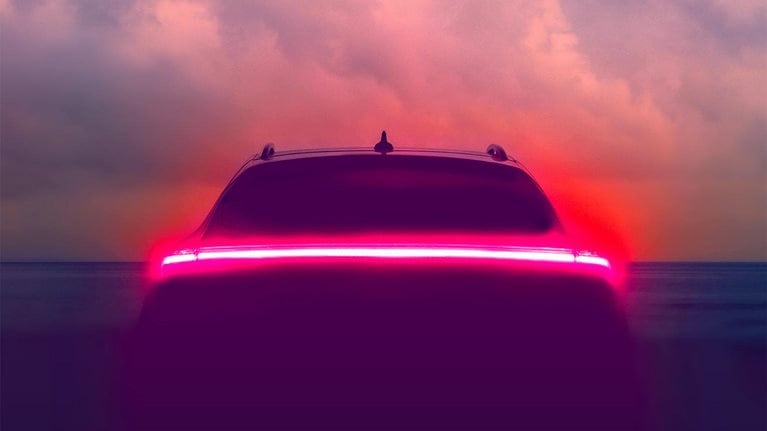 Brake lights glowing on an autonomous vehicle with a hazy blue sky in the background