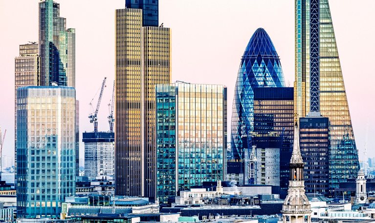 Sunset view of London's financial district, including The Gherkin and The Shard.